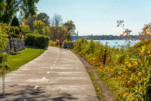 People Riding Bicycles On The Trail Along The River