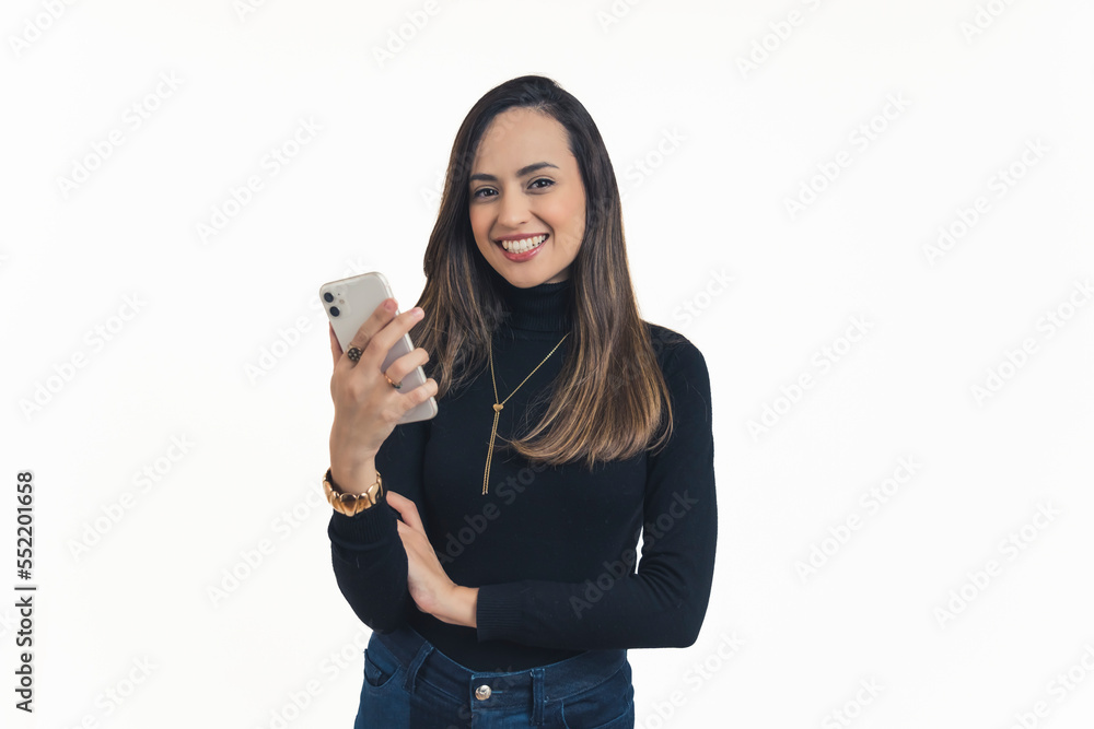 medium shot of an attractive Latin-American girl holding her phone and posing for the camera, isolated white background studio shot social network concept. High quality photo medium shot of an attractive Latin-American girl holding her phone and posing for the camera, isolated white background studio shot social network concept. High quality photo