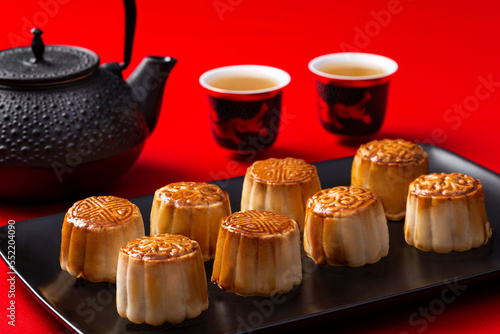 Chinese moon cakes on a black plate on a red background
