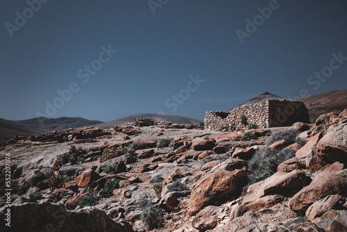 Fuerteventura dessert oasis mountain rocks stones dry sparse palm shelter ruin cabin tent horizont wallpaper blue low saturated mood Aloe Vera