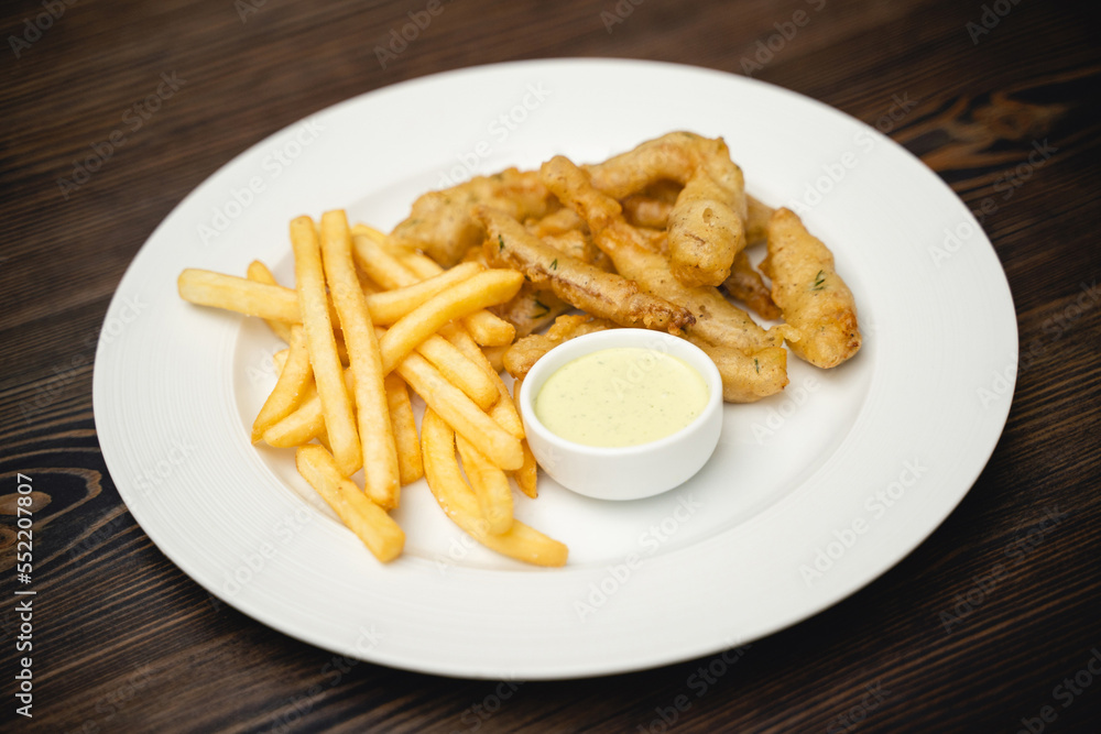 menu with fried shrimp and french fries with sauce on a plate.