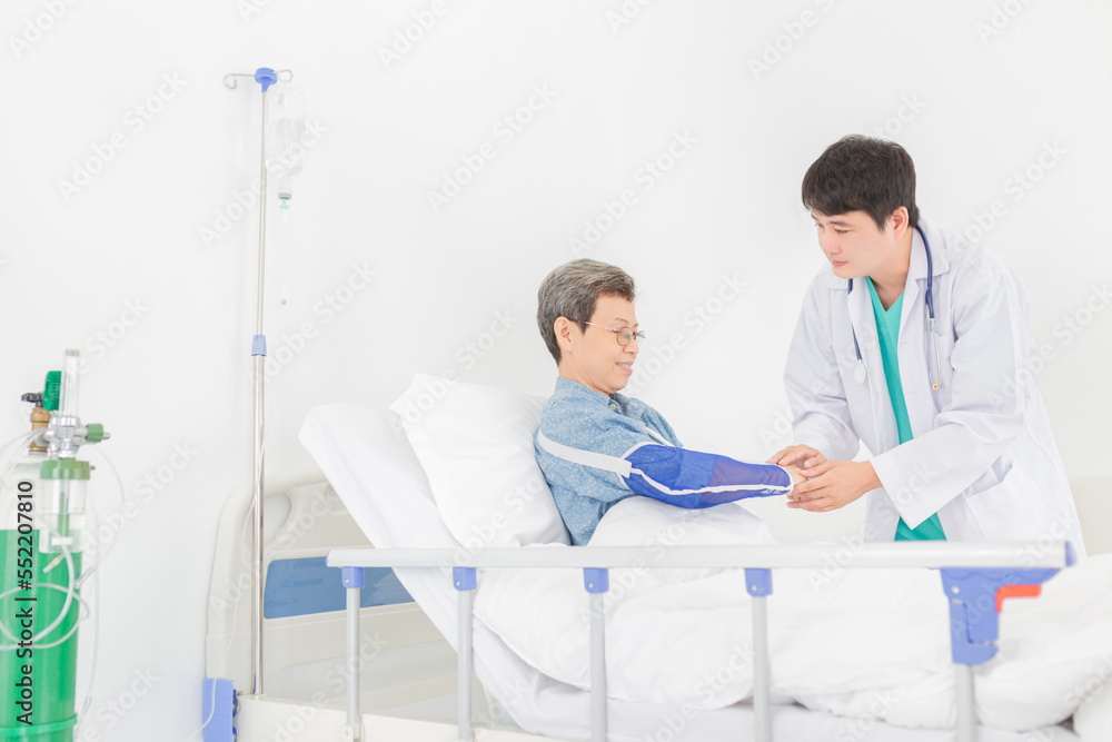 Fototapeta premium asian patient talk with doctor in hospital, doctor assessment and explaining about treatment information, patient wear arm splint, elderly healthcare treatment