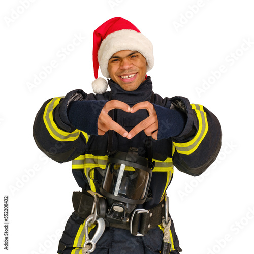 Young smiling African-American fireman in uniform and red Santa Hat showing heart sign with fingers and looking at camera, vertical orientation 