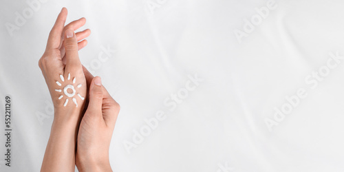 Sun painted with cream on hands against white background  closeup view with space for text. Banner design