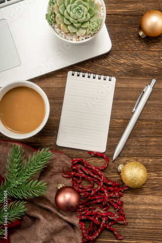 Christmas background with Laptop, blank notebook, fir branches, decorations. Space for text. Top view. Christmas to-do list or wish list.