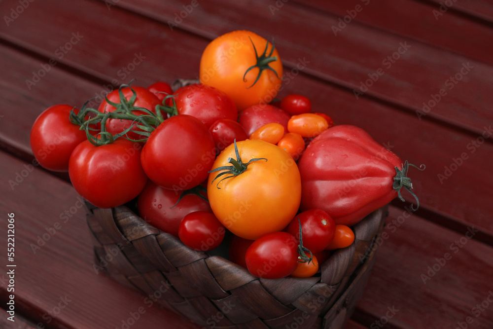 Basket with fresh tomatoes on wooden table Basket with fresh tomatoes on wooden table