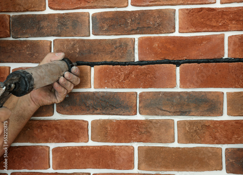 Professional builder using tiling fugue for grouting, closeup