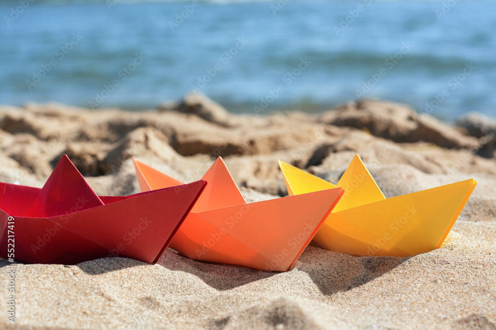 Three paper boats near sea on sunny day, closeup Three paper boats near sea on sunny day, closeup