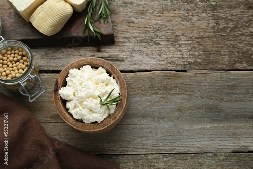 Delicious tofu cream cheese with rosemary on wooden table, flat lay. Space for text