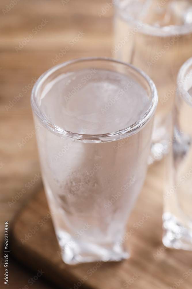 Vodka in shot glasses on wooden table, closeup Vodka in shot glasses on wooden table, closeup