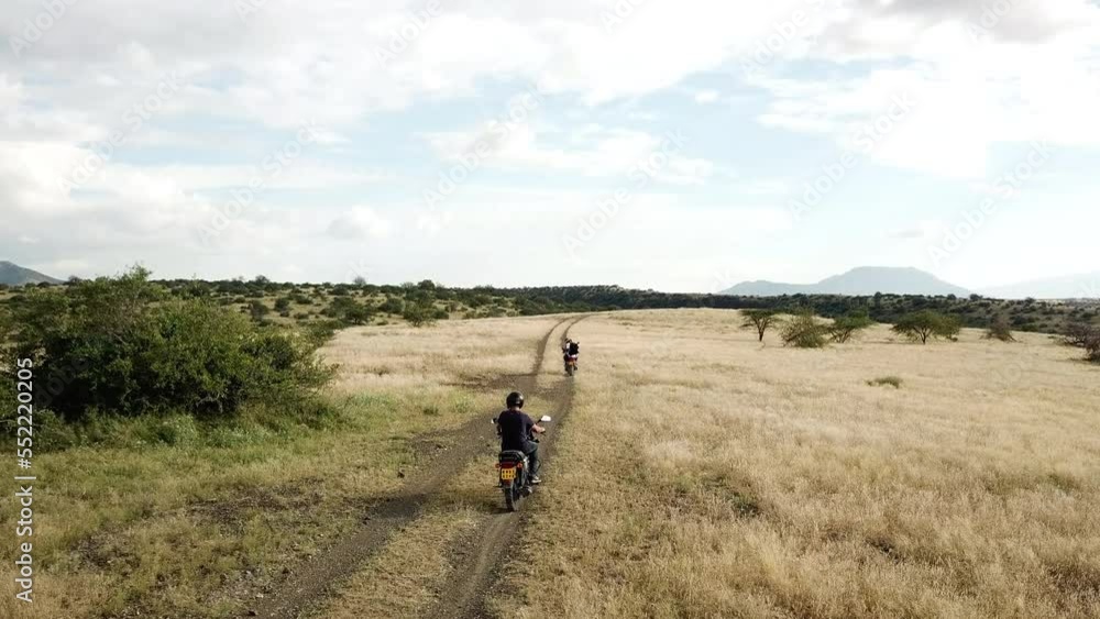 4k Aerial view of motorcyclists riding in a line on an arid road in East Africa. 4k Aerial view of motorcyclists riding in a line on an arid road in East Africa.