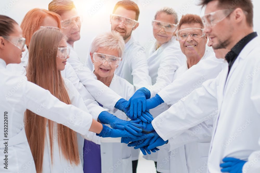 group of medical researchers making a tower out of their hands. group of medical researchers making a tower out of their hands.