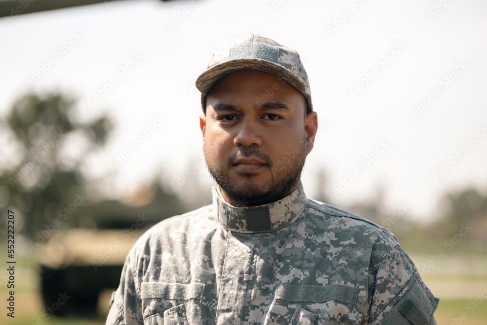 Asian man special forces soldier standing against on the field Mission. Commander Army soldier military defender of the nation in uniform standing near battle tank while state of war.