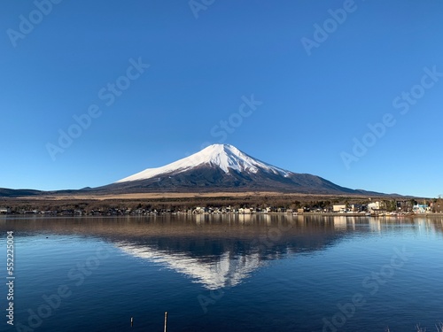 Magnificent Mount Fuji with reflection in the clear blue waters surrounding it.