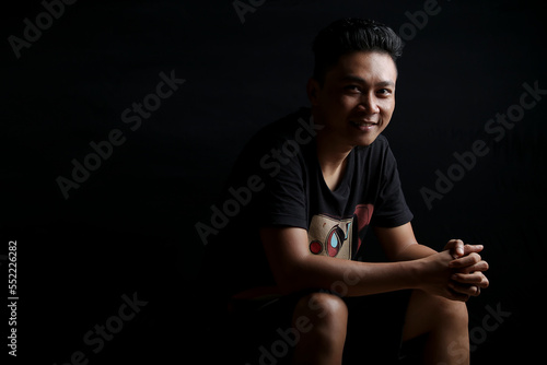 young asian man portrait smiling isolated black background