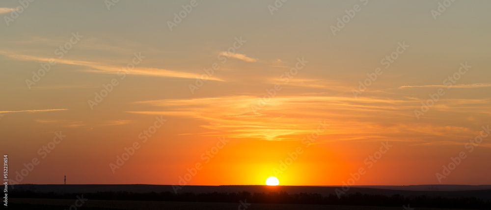 Panorama. Landscape with dawn. The sun rises through light cirrus clouds.