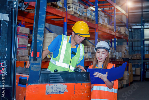 Portrait asian engineer in helmets order on tablet for checking goods and supplies on shelves with goods background in warehouse.logistic business export ,Warehouse worker checking packages on store