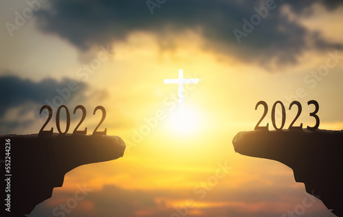 Fotografija New hope concept: 2023 on sunset sky background with white cross