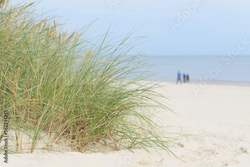 Strand bei Swinoujscie auf der Insel Usedom an der polnischen Ostseek  ste. Im Hintergrund drei verschwommene Spazierg  nger