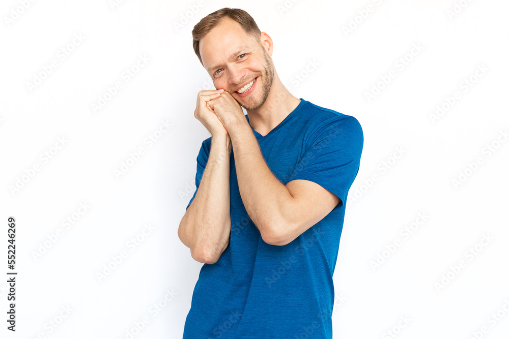 Touched man smiling at camera, holding hands together over cheek. Man being kind, affected or melting from cuteness while standing on white background. Trust, kindness, love, appreciation concept Touched man smiling at camera, holding hands together over cheek. Man being kind, affected or melting from cuteness while standing on white background. Trust, kindness, love, appreciation concept