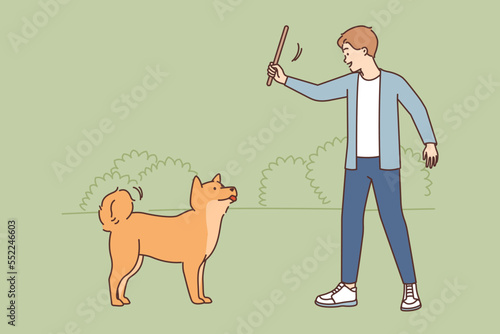 Smiling man training with dog in park 