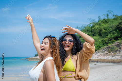 Two Asian beautiful girls happy together on the beach Holiday in summer.