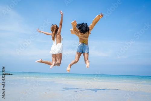 Two attractive girls jumping on the beach,Having Fun,Summer Lifestyle.