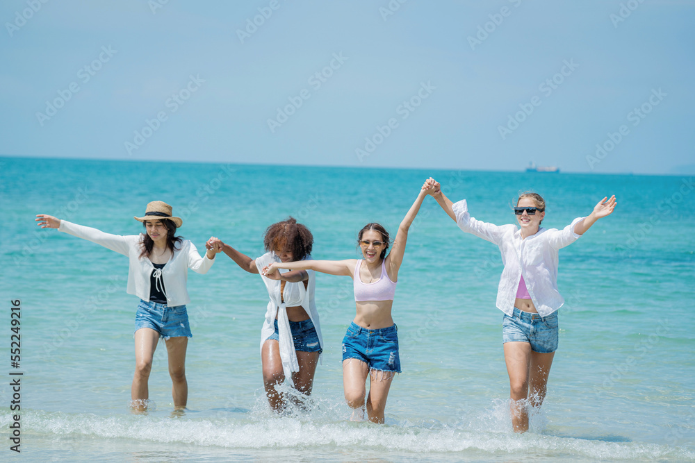 Happy women with friend are playing on the beach While relaxing on vacation for the weekend on sunny day.