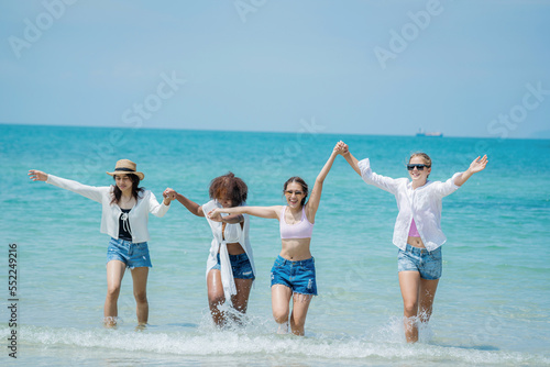 Happy women with friend are playing on the beach While relaxing on vacation for the weekend on sunny day. © visoot