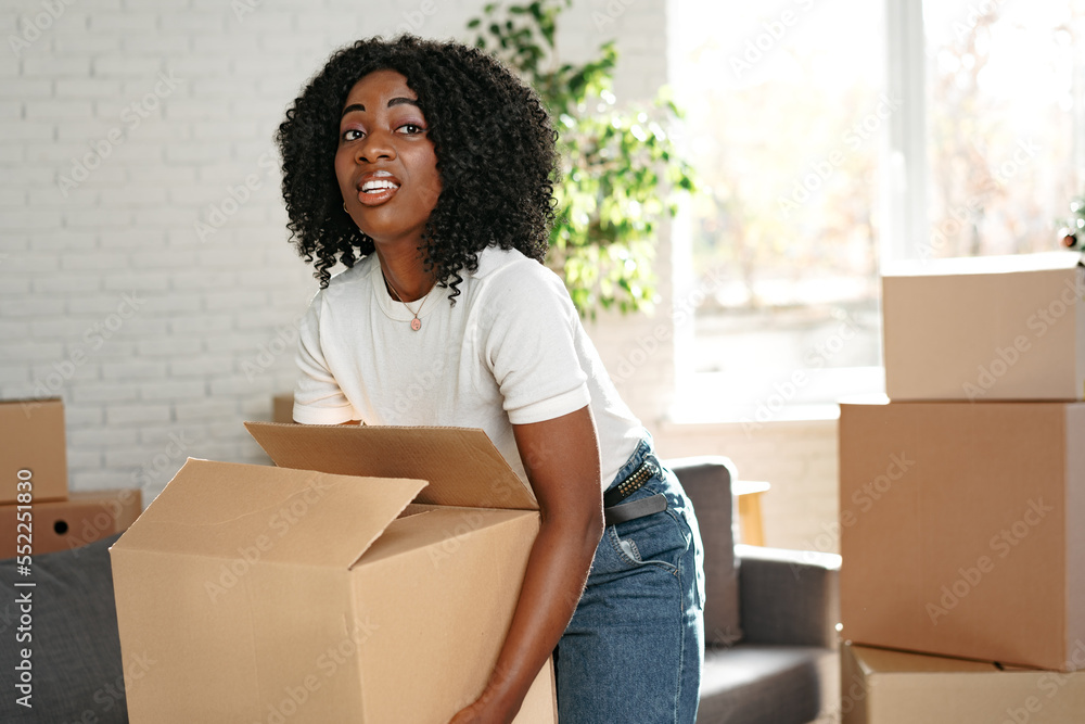 Happy african young woman with cardboard box moving to a new place Happy african young woman with cardboard box moving to a new place