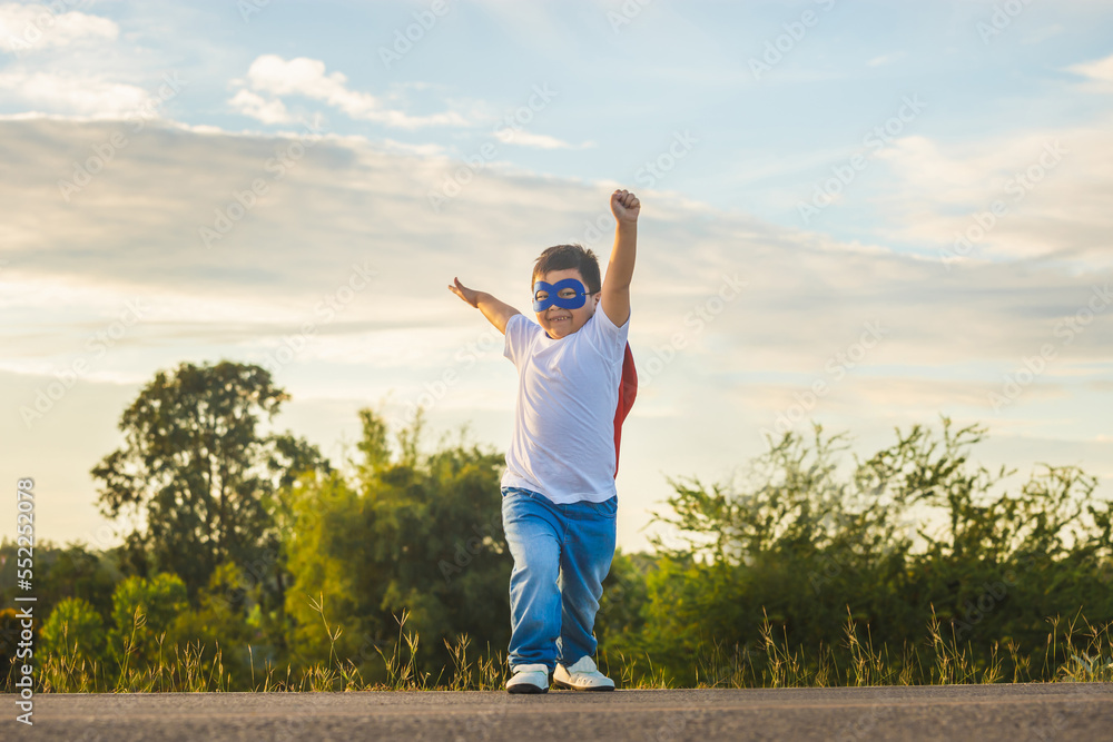 Fototapeta premium Portrait of adorable kid boy having fun outdoor. Little child play superhero