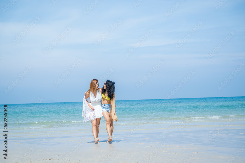 Two women playing together in the sea at the beach.