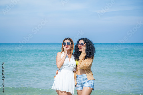Two women playing together in the sea at the beach. © visoot