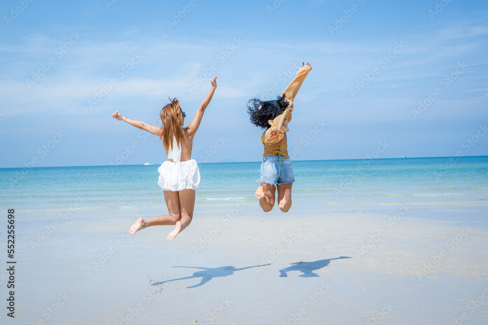 Two attractive girls jumping on the beach,Having Fun,Summer Lifestyle.