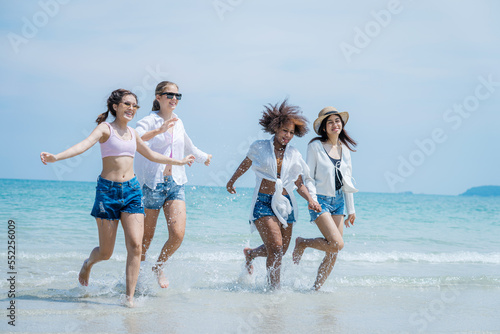 Young women and friends playing at the beach on a sunny day,Happy friends together at the beach.