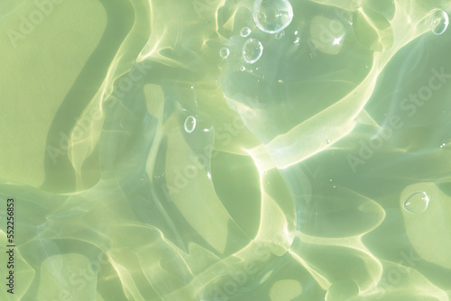The texture of a green gel or serum with hyaluronic acid for the face. Cosmetic transparent liquid cream with oxygen bubbles. Wellness and beauty concept. Sanitizer, virus protection.