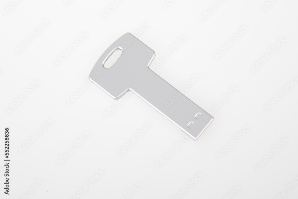 metal silver key USB flash drive memory ready to connected on white desk grey background metal silver key USB flash drive memory ready to connected on white desk grey background