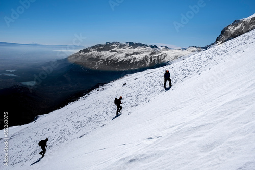 mountaineers climb to the summit together on a difficult and steep slope © emerald_media