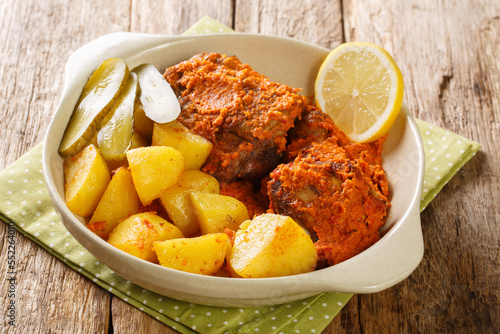 African and Portuguese cuisine galinha a Africana or frango assado is a dish traditionally associated with Macau close up on the pot on the table. Horizontal photo