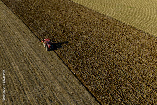 Farm field, farmers work with tractor on farmland,