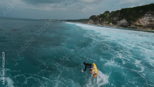 Surfer athletic man riding wave shirt surfboard tropical resort extreme sport leisure activity aerial panorama view. Male surfing paradise island sea ocean water natural landscape tourism FPV drone 4k