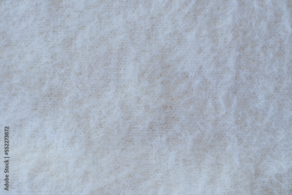 Soft beige knitted fabric as background, closeup. Fluffy fabric for the whole picture Soft beige knitted fabric as background, closeup. Fluffy fabric for the whole picture
