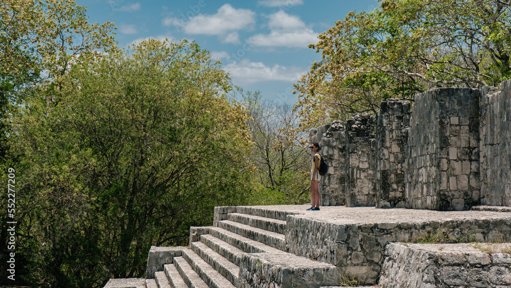 Fototapeta premium Woman staring in front of the ruins of the mayas pyramids at Edzna, Yucatan 