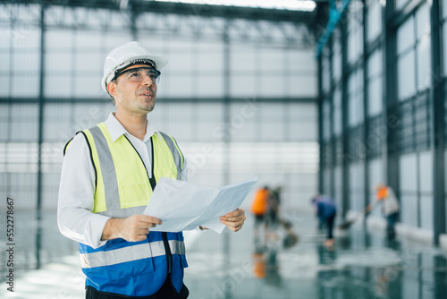 warehouse manager with tablet and ..radio communication his worker working in background in warehouse distribution center environment. Business warehouse inventory,contruction warehouse