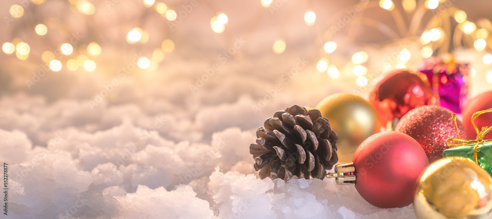 Fototapeta premium Christmas ball on snow and Christmas tree decoration on blurred background christmas background design, bokeh lights.