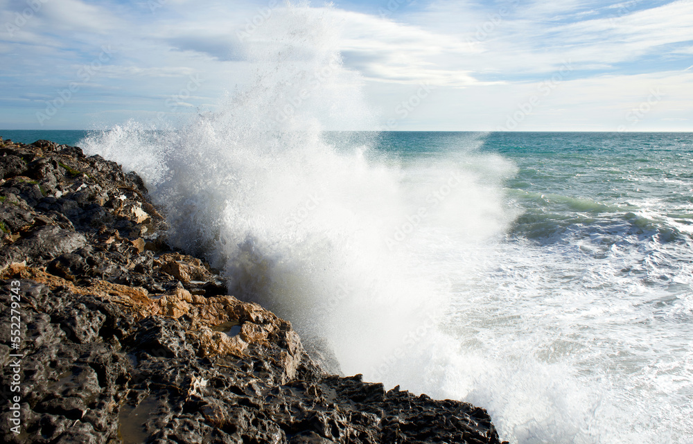 Wave crashing against rocks. Wave splashing.