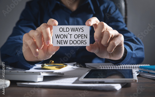 Man showing Old ways won't open new doors. Motivational quote