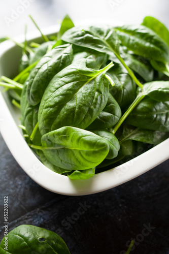 Fresh spinach leaves in a bowl, green vegetables, rustic style, healthy lifestyle, proper nutrition.