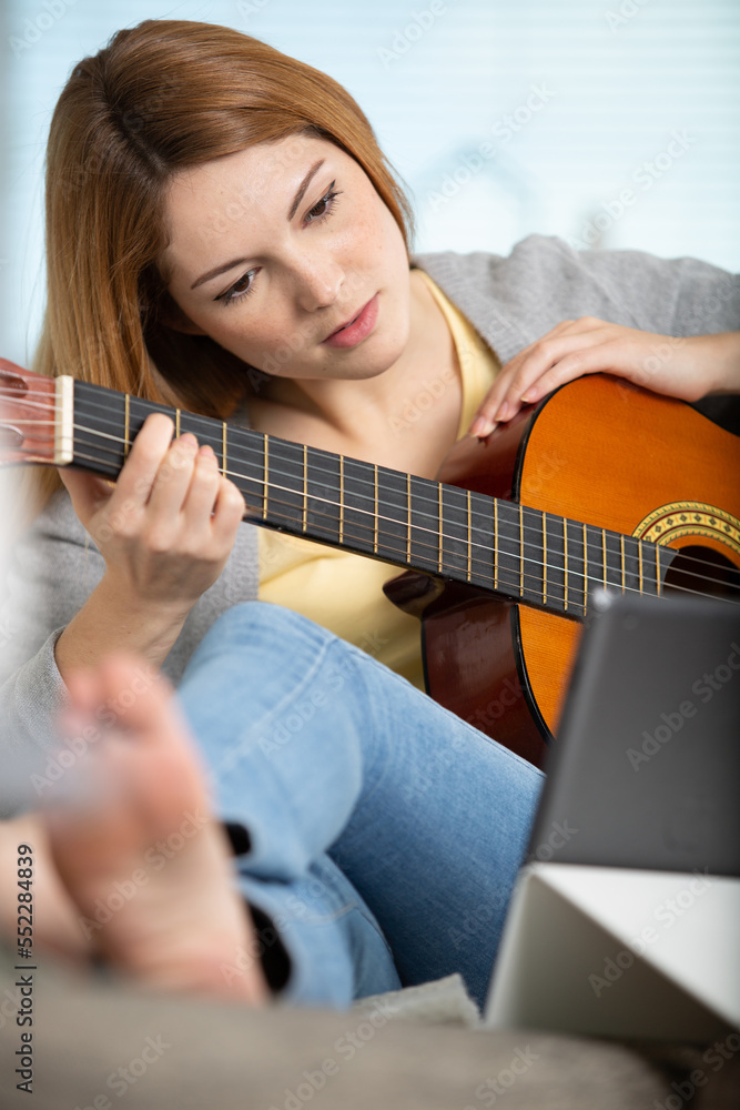 Fototapeta premium happy smiling woman using guitar and tablet