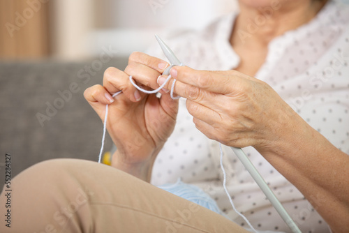 close up of the hands of a woman knitting